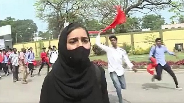 কমলা বা গেরুয়া স্কার্ফধারী উগ্রপন্থী তরুণদের আক্রমনাত্মক প্রতিরোধের মুখে পড়ে বিবি মুসকান খান